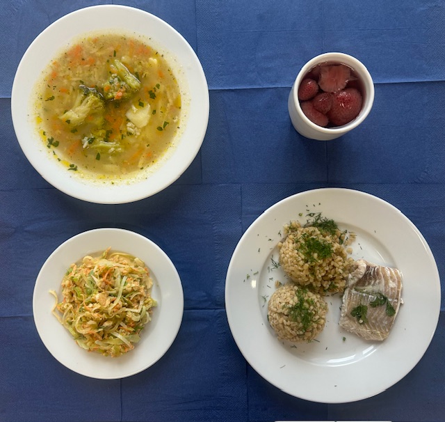 na talerzach zupa krupnik ryżowy z brokułem, kasza pęczak, dorsz pieczony, surówka z pora i jabłka, w kubku kompot 