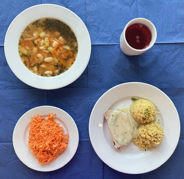 na talerzach zupa grochowa, kasza bulgur, schab pieczony, kasza bulgur, sos ziołowy, w kubku kompot 