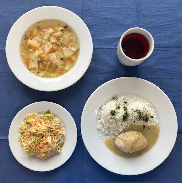 na talerzach zupa zacierka, pulpet rybny, ryż basmati, sos pietruszkowy, surówka z pora jabłka i marchwii w kubku kompot