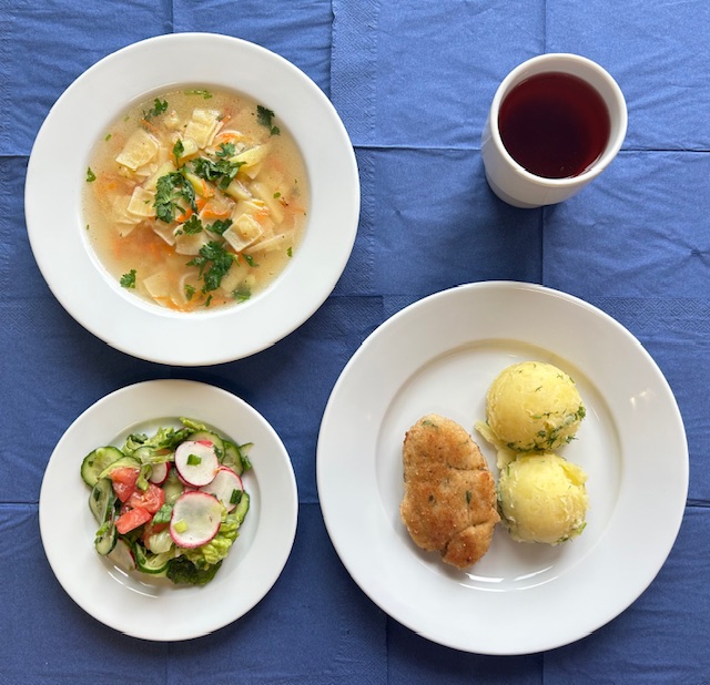 na talerzach zupa zacierka kotlet rybny smażony, ziemniaki, surówka wiosenna, w kubku kompot