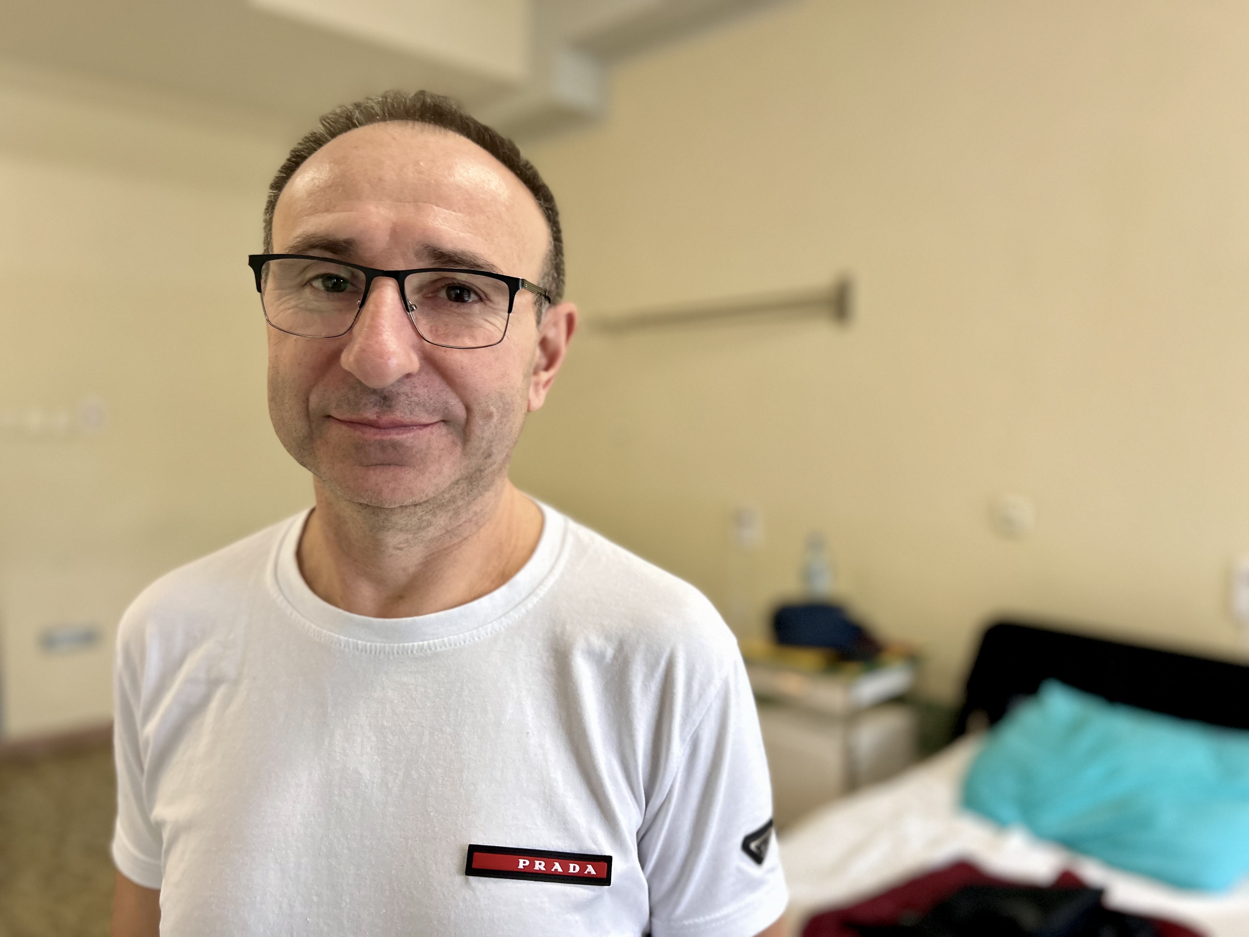 Pacjent Artur Chudziak w sali szpitalnej przed łóżkiem