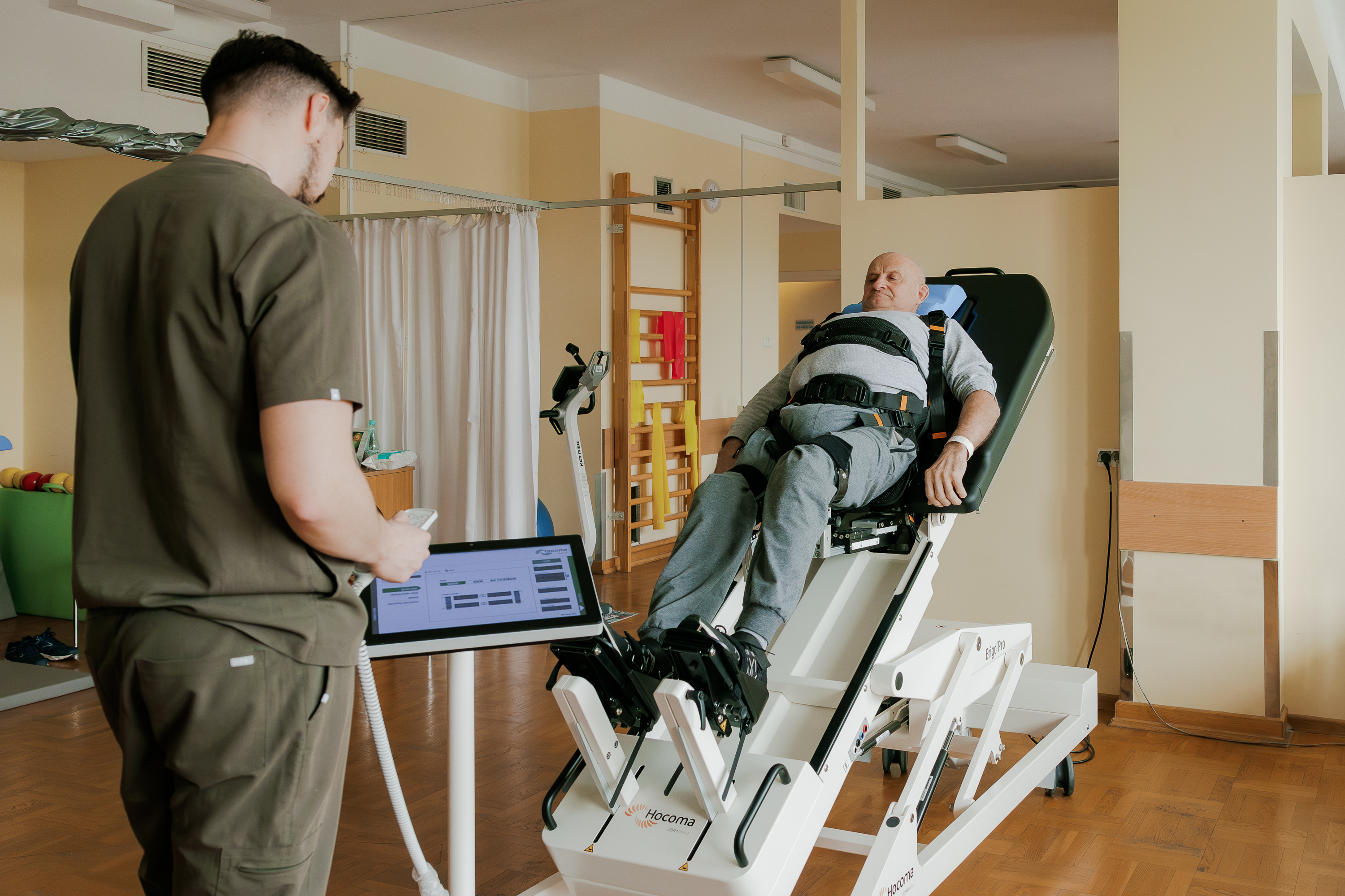Fizjoterapeuta oraz pacjent na stole pionizującym w sali gimnastycznej