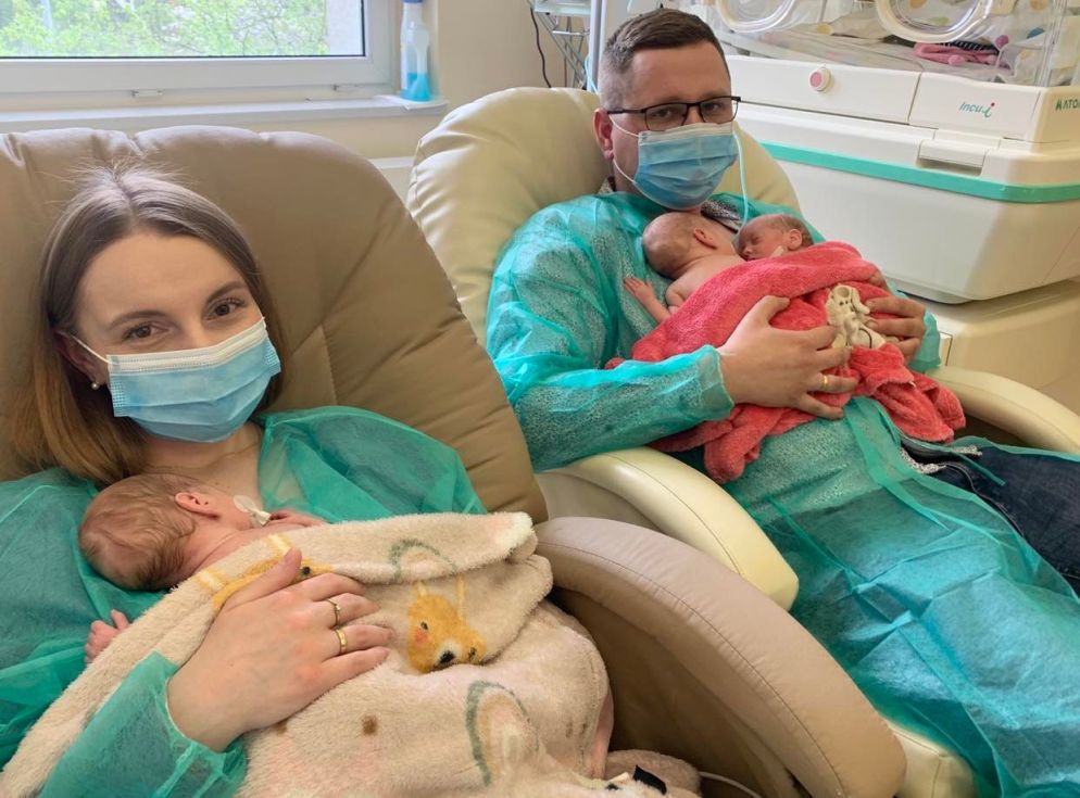 Trojaczki z rodzicami w sali neonatologicznej widok z boku