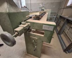 Szlifierka taśmowa widziana z boku od strony wałka.