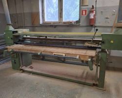 Szlifierka taśmowa widziana z przodu, z widocznym stołem roboczym.