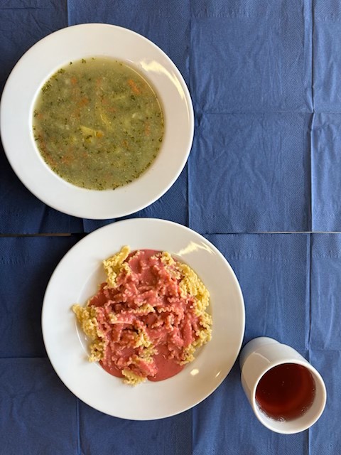 na talerzach zupa szpinakowa, makaron z truskawkkami, w kubku kompot 