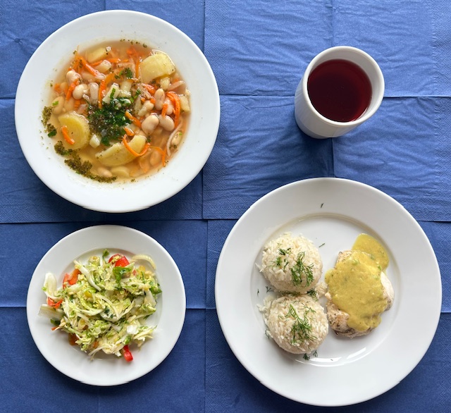 na talerzach zupa fasolowa, bitka drobiowa, sos curry, ryż paraboliczny, surówka z kapusty pekińskiej, papryki z sosem vinegret, w kubku kompot