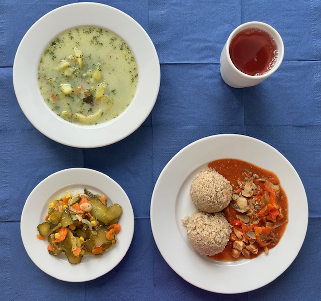 na talerzach zupa szpinakowa, kasza jęczmienna, gulasz mięsno -warzywny, surówka z ogórka kiszonego, w kubku kompot 