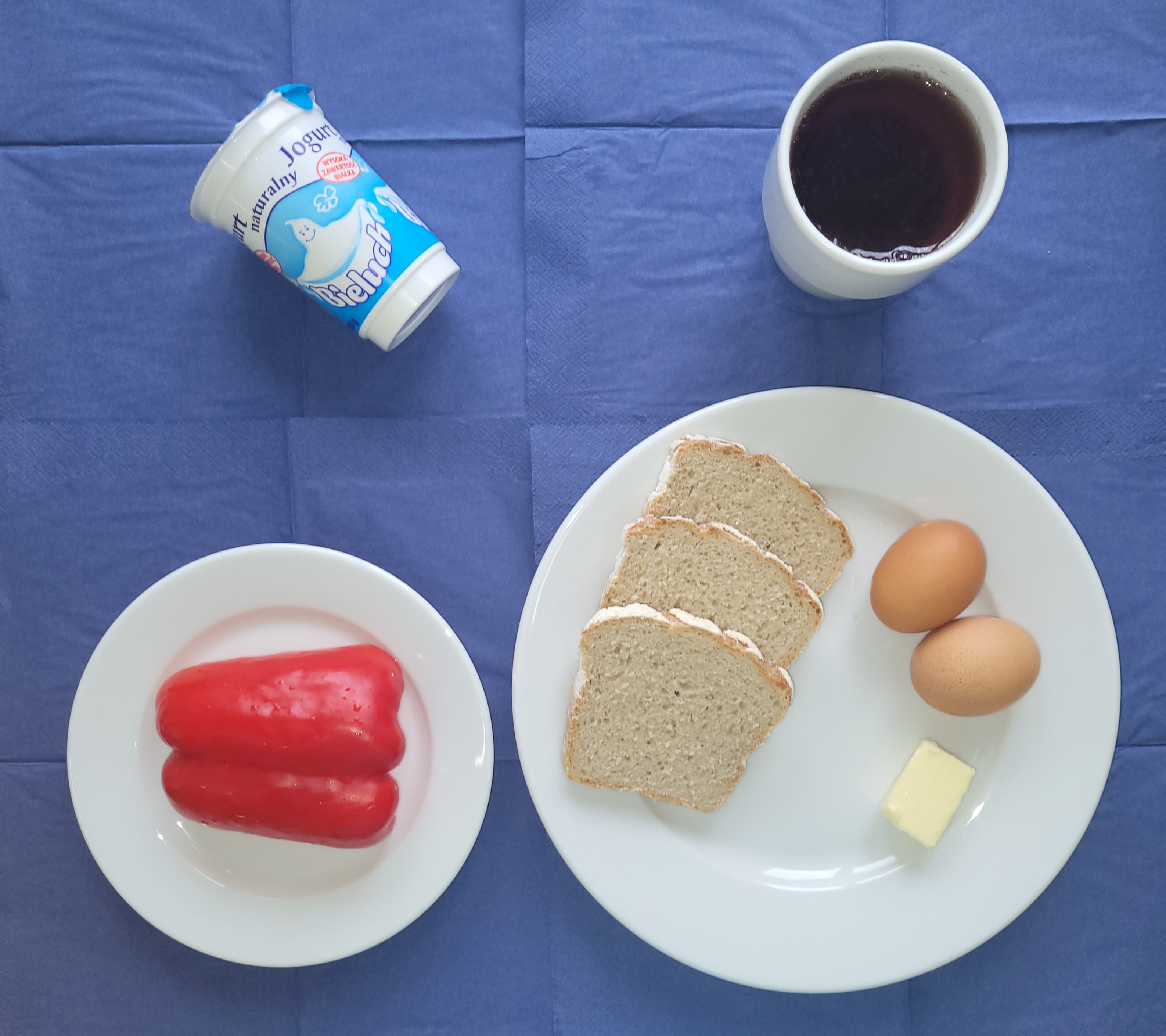 na talerzach chleb żytni, masło, jajko gotowane 2 sztuki, papryka, kefir, w kubku herbata z cytryną bez cukru