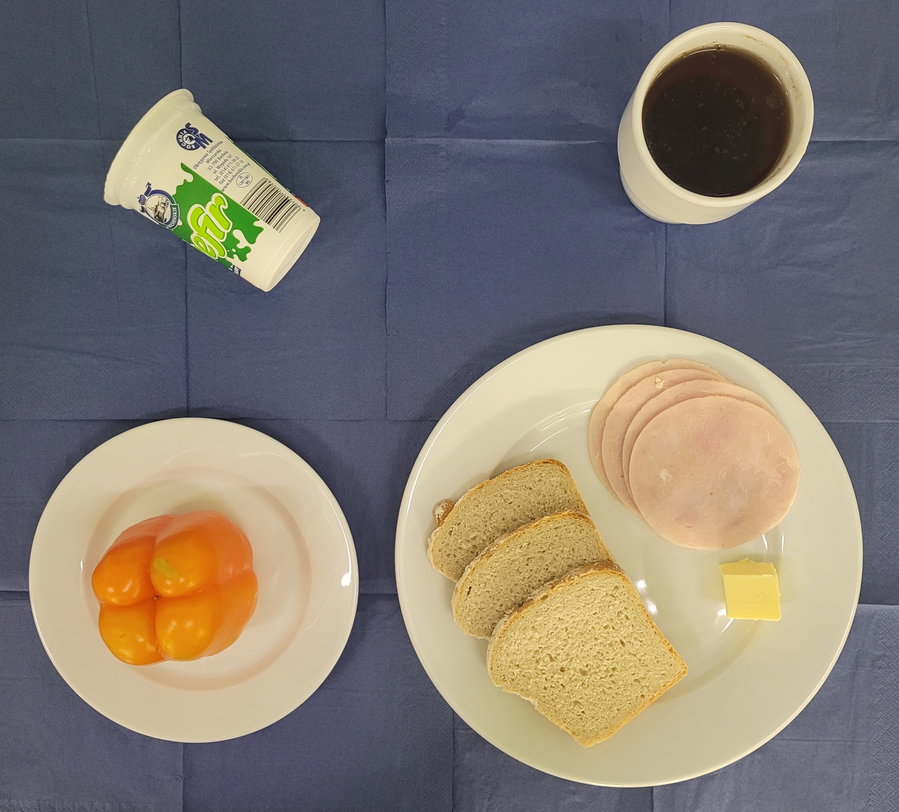 na talerzach chleb razowy, masło, szynkowa, papryka, kefir, herbata z cytryną