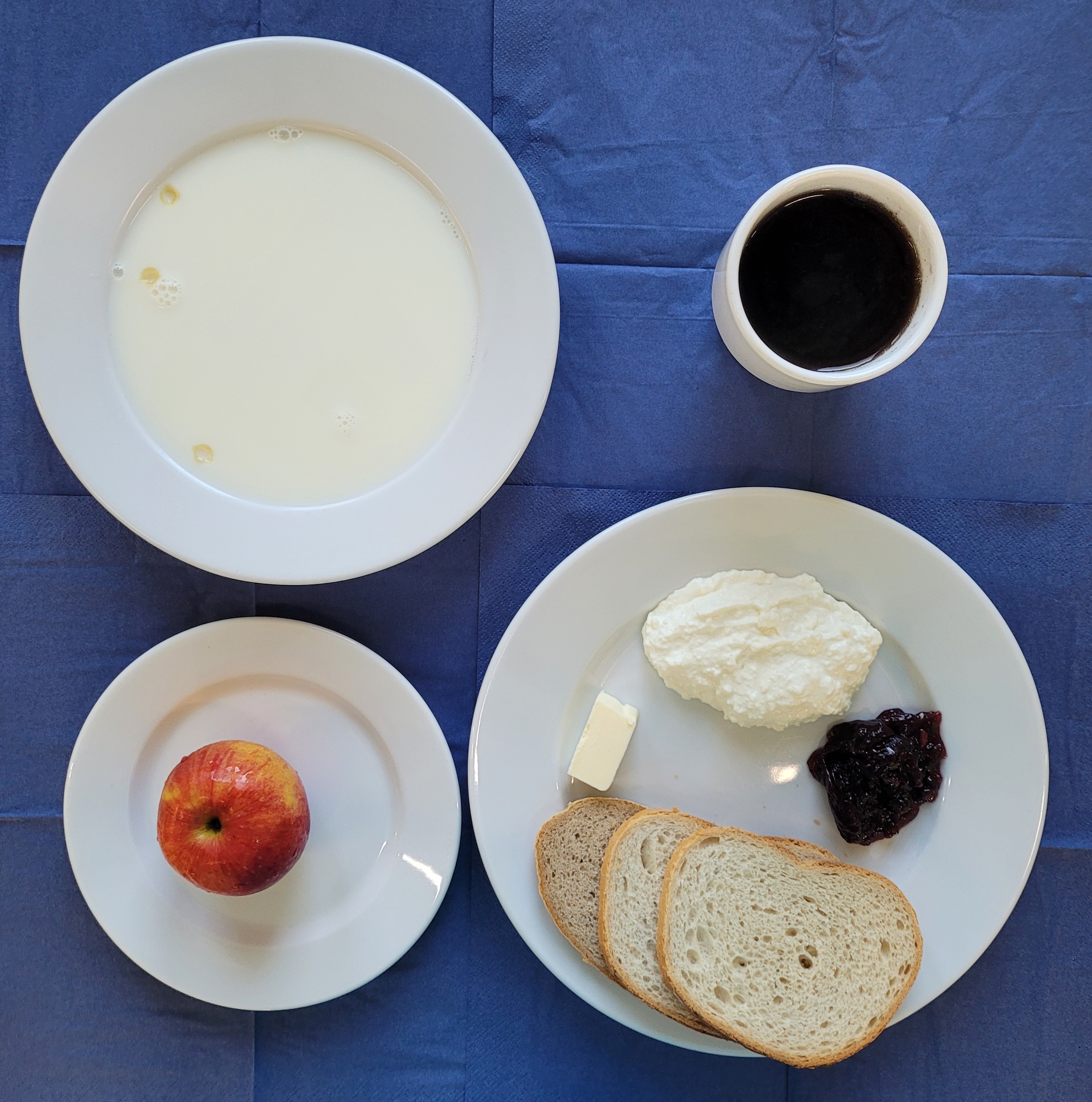 na talerzach makaron na mleku, chleb pszenny, chleb sitkowy, masło, ser biały, dżem, jabłko, w kubku herbata z cytryną