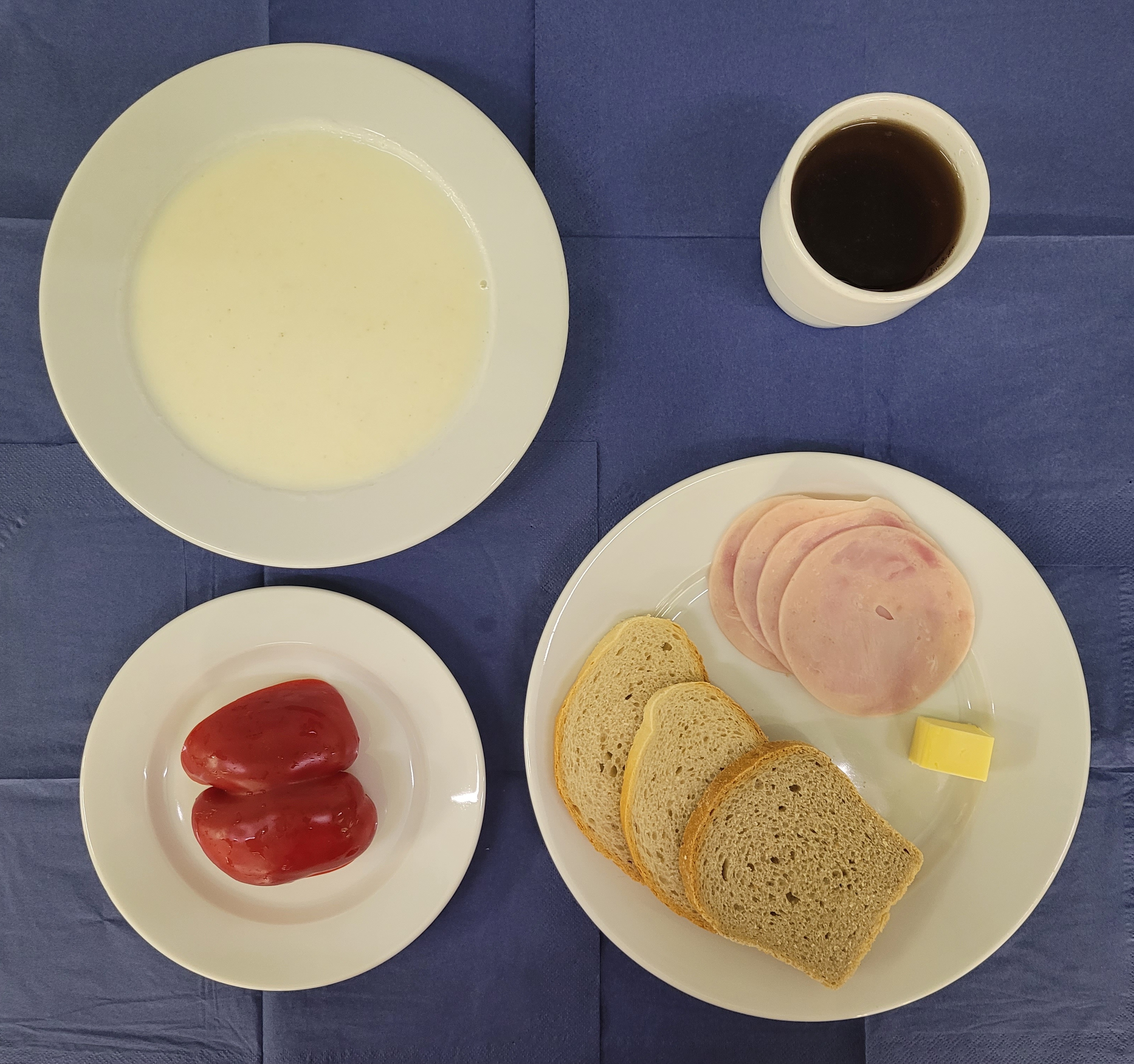 na talerzach płatki jaglane na mleku, chleb pszenny, chleb sitkowy, masło, szynkowa, papryka, w kubku herbata z cytryną