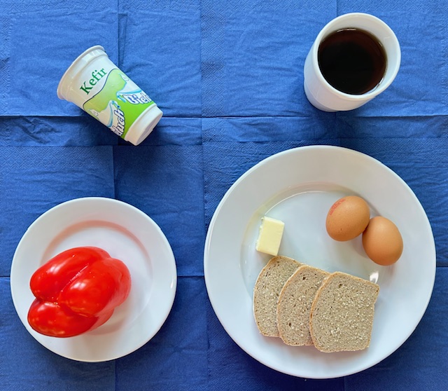na talerzach chleb razowy, masło, jajko gotowane 2 sztuki, papryka, kefir, herbata z cytryną 